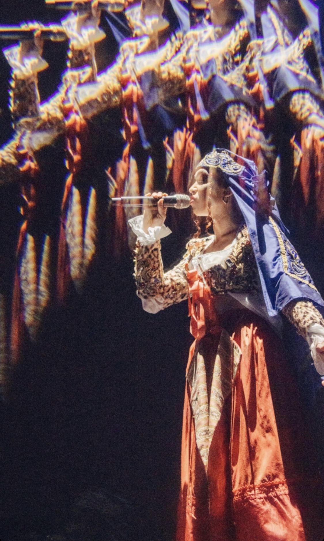 FKA Twigs singing into a microphone during performance
